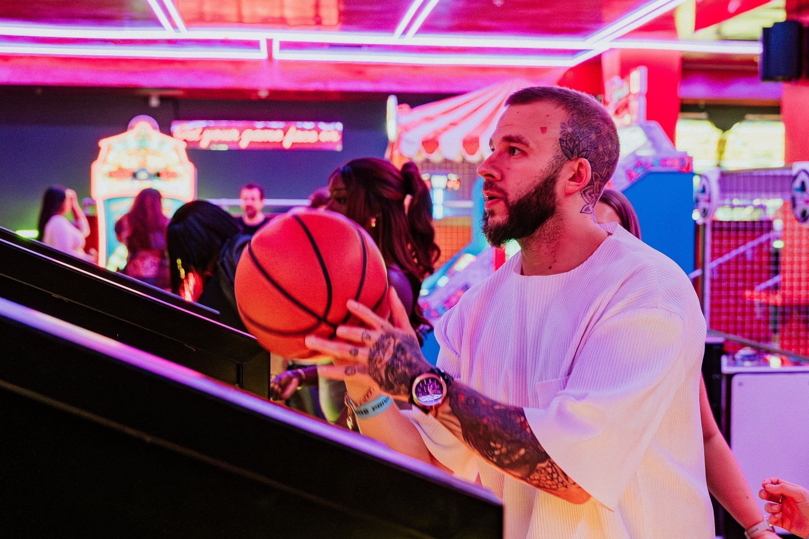 Someone concentrating on lining up a basketball shot in an arcade